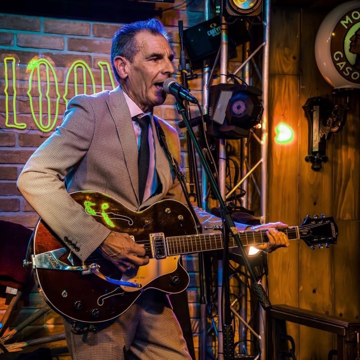 Guitarist close-up at the Western Saloon neon sign