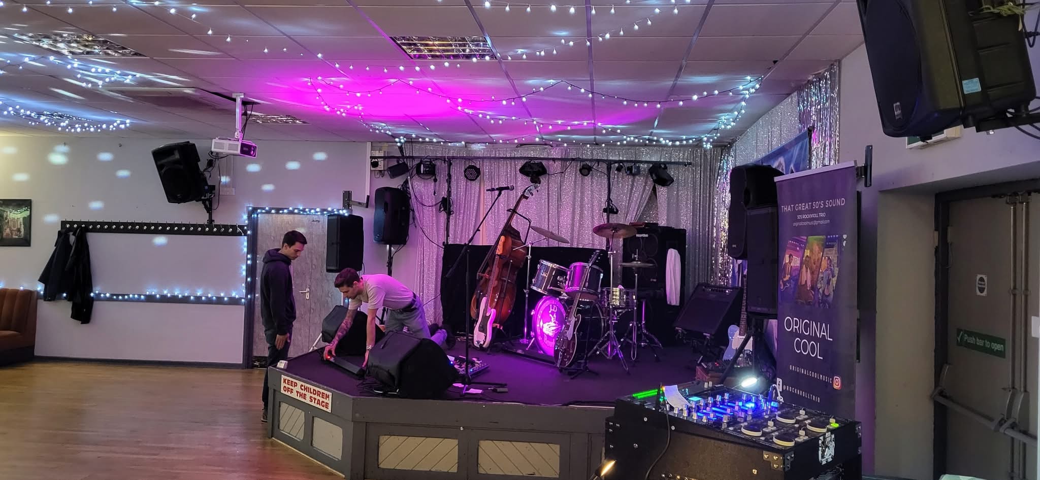 Setting up on stage — Original Cool banner in shot
