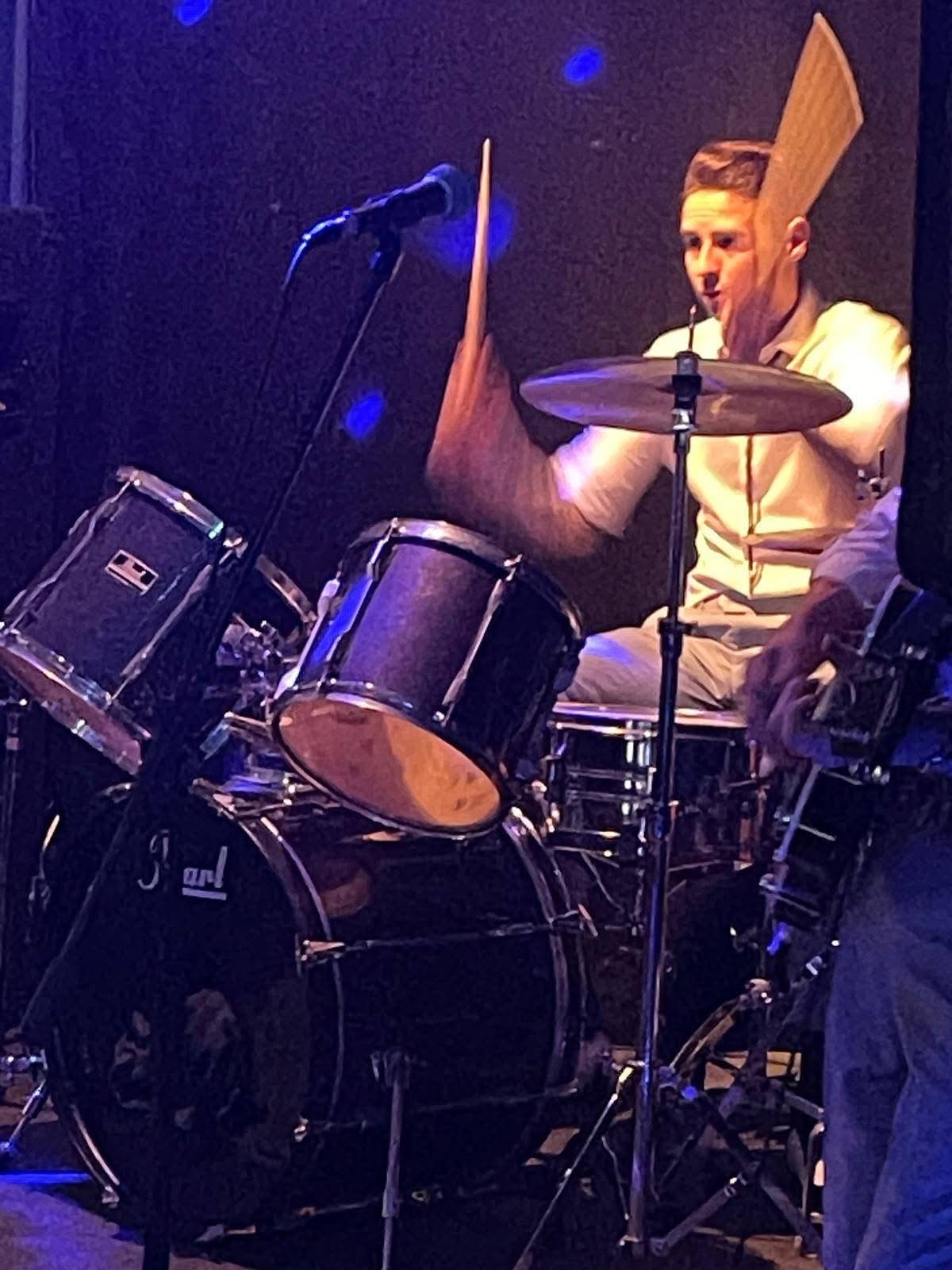 Drummer in action — sticks in the air
