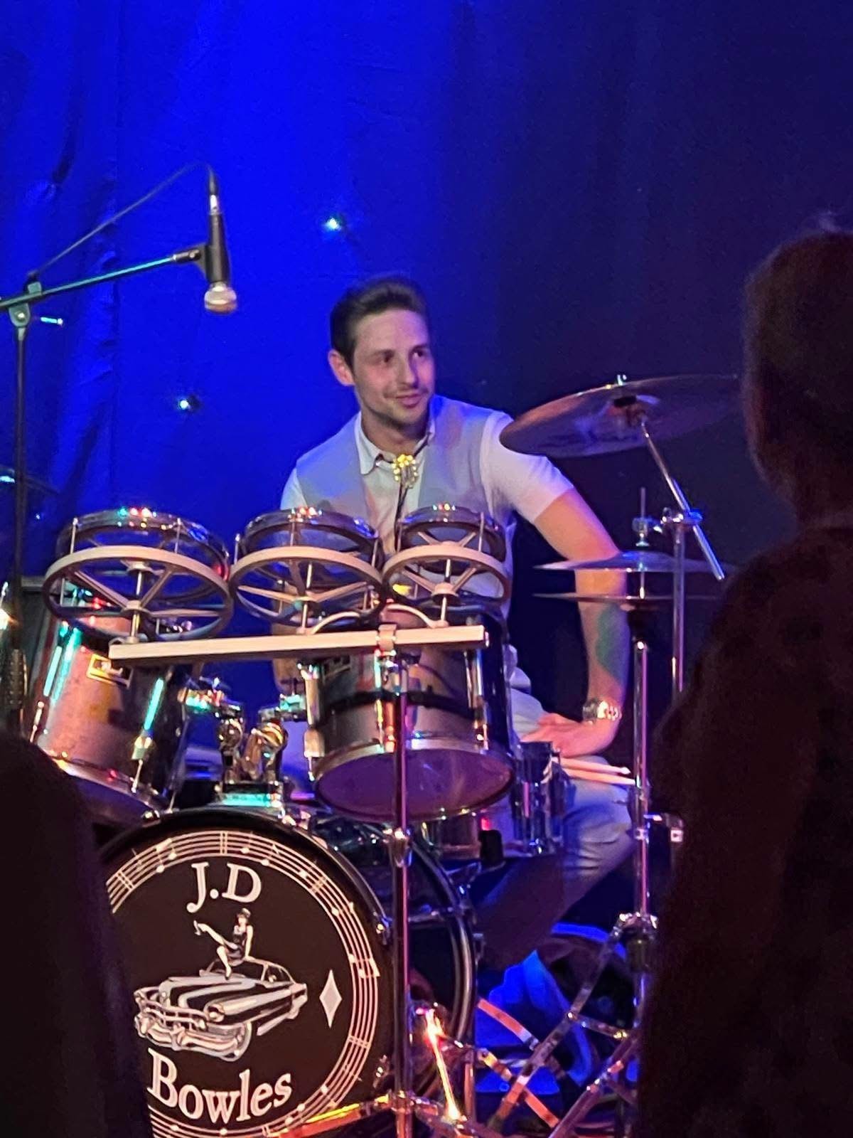 JD Bowles on drums — blue stage lighting