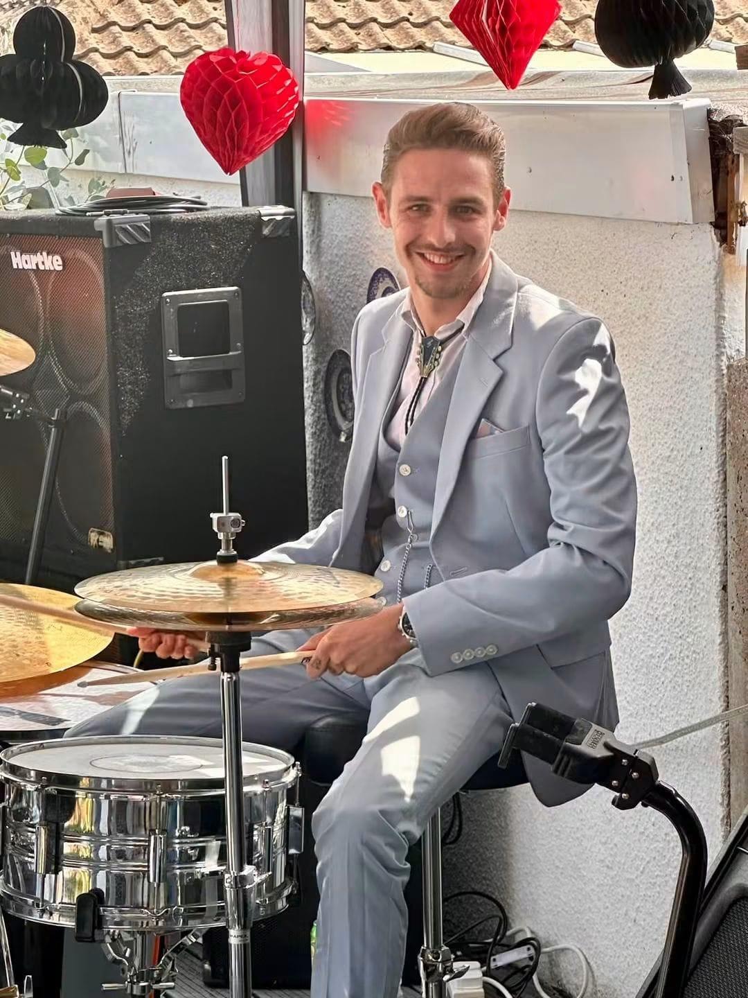 Drummer smiling at an outdoor garden party gig